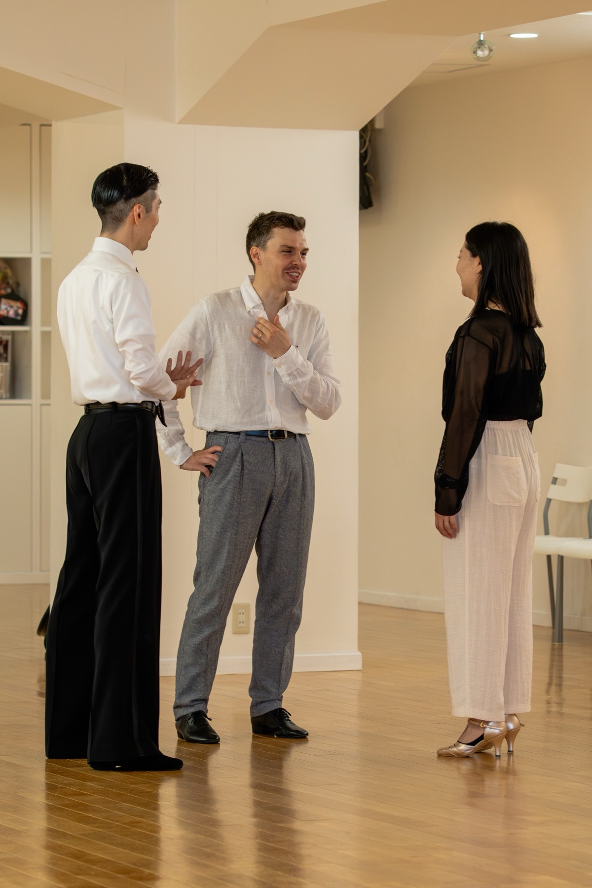 Koji chatting with two students on the studio floor